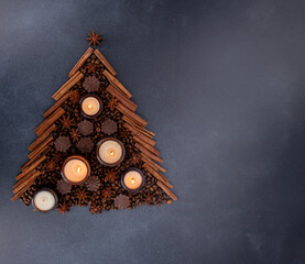 Soy scented candle in a jar. Coffee beans, anise, cinnamon spices. The candles are burning. Dark background