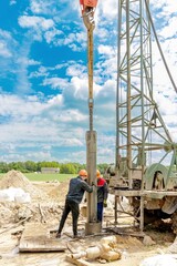 Worker drilling into the earth with his well drilling machine to extract water. Drilling equipment, drills well for water extraction