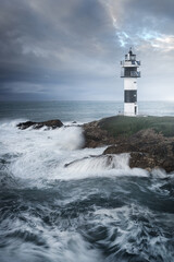 Cloudy sunset over the Isla Pancha lighthouse in Ribadeo, Lugo, Galicia