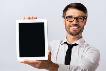 Smiling Business Man Showing Empty Tablet Computer Screen On White Studio Background. Mockup