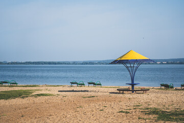 Gazebos with a yellow dome on the beach by the lake