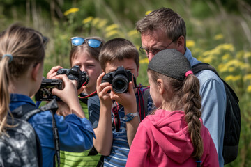 A group of kids are being taught photography outdoors by an adult, engaging in a fun and educational activity. World Photo Day