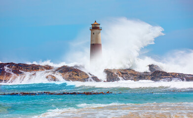 Beautiful red and white lighthouse on the rocks with strong sea wave - Namibia, Africa
