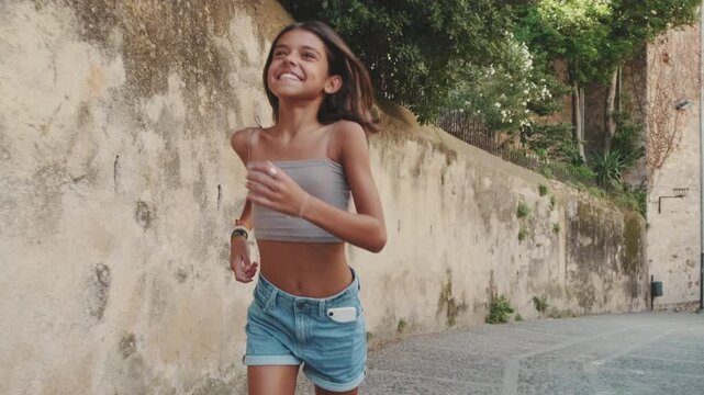 Adorable European girl rinning outside in the summer