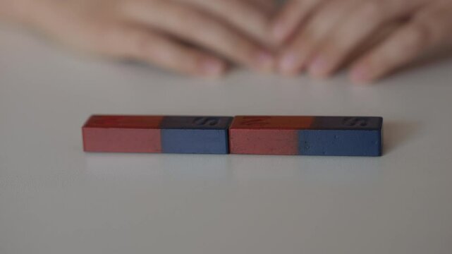 School Science Educational Experiment With Magnets. Child Hands Moves Two Magnets Around So That They Attract And Repel Each Other. Magnetic Force Demonstration Showing Attraction And Repulsion.