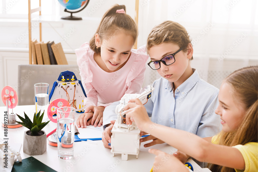 Poster Three young children are working on a science project in a classroom. The children are collaborating on a mechanical project, building a robot or machine together