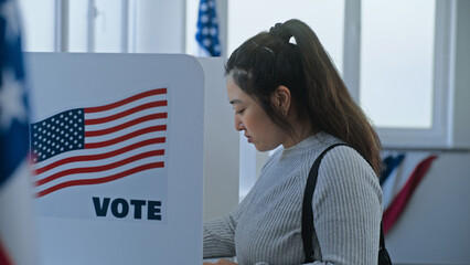 Multi ethnic American citizens come to vote in booth in polling station office. National Election...