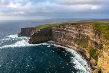 North side of the Cliffs of Moher illuminated by the soft light of sunset