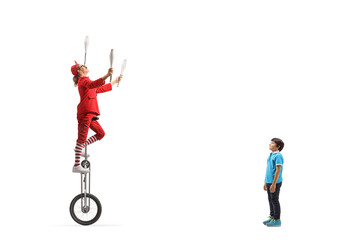 Boy watching an entertainer riding a giraffe unicycle and juggling © Ljupco Smokovski