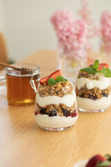 Yogurt with crispy granola, berries and honey for a delicious breakfast. Healthy eating.