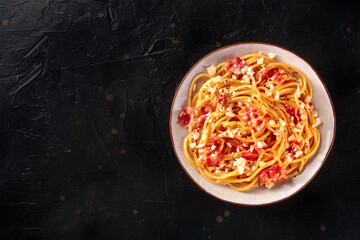 Carbonara pasta dish, traditional spaghetti with pancetta and cheese, shot from the top with a place for text on a dark background