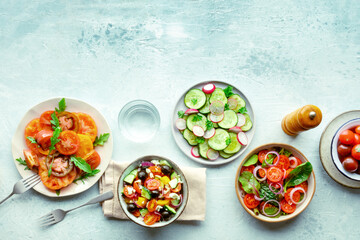 Fresh vegetarian salads, overhead flat lay shot of an assortment. Variety of plates and bowls with green vegetables. Healthy food, with copy space