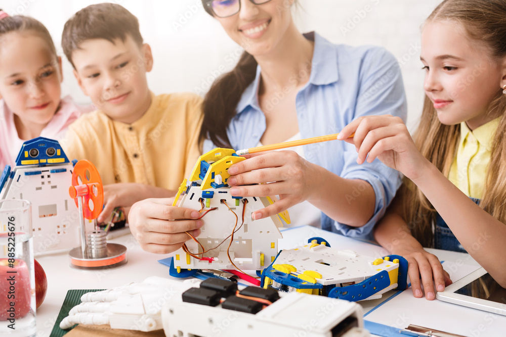 Aufkleber A teacher guides a group of children as they work together to build a robot. The students are focused and engaged, learning about STEM concepts through hands-on experience.