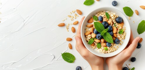A white bowl containing cereal with toppings of berries, nuts on top and around it with a white background
