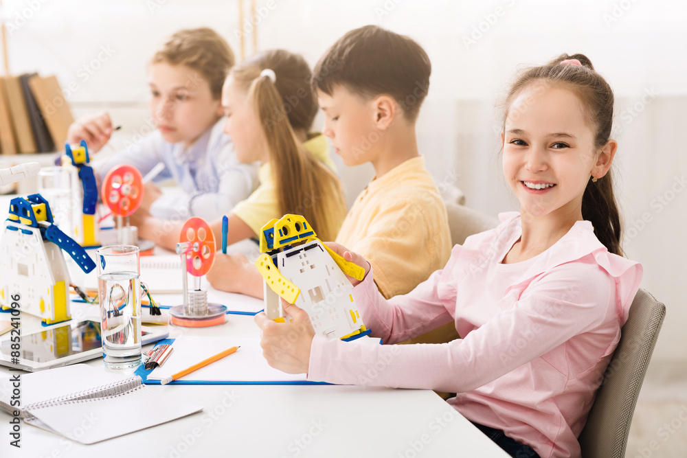 Poster this image shows a group of children in a classroom setting, engaged in a stem activity. they are wo
