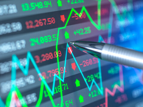 Pen with stock market data on screen