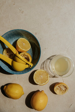 Halved lemons, lemon squeezer and glass of lemon juice