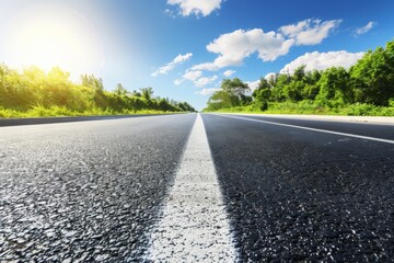 Fototapeta premium Sunny day on an empty highway surrounded by greenery
