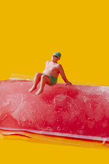 miniature man sitting on a freeze pop
