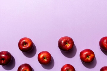 Many red apples on colored background, top view. Autumn pattern with fresh apple above view