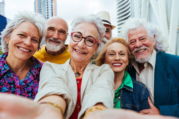 Happy elderly friends taking selfie together