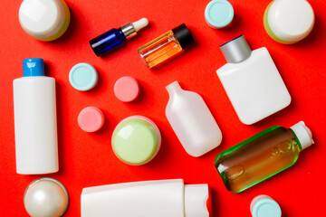 Top view of different cosmetic bottles and container for cosmetics on colored background. Flat lay composition with copy space