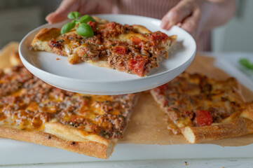 Homemade pizza served by a woman with apron