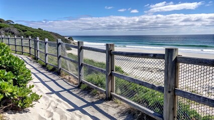 Fototapeta premium Fence leading towards the beach on a sunny summer day , Beach, sand, ocean, vacation, travel, sunny, blue sky