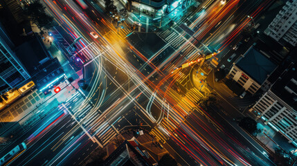 A busy city intersection at night, with headlights and tail lights creating light trails