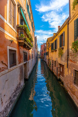 Venice, Italy - June 03, 2024: Narrow canal framed between colorful buildings.