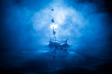 Water splash on dark foggy background. Selective focus.