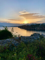 View of bay, plants, coast and mountains at sunset, vertical landscape in Antalya, Turkey