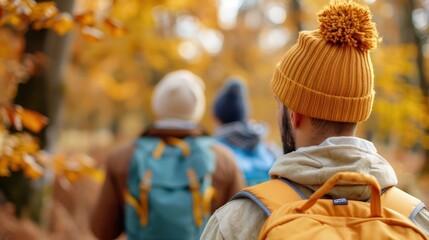 A group of hikers wearing warm beanies treks through a forest in fall, with colorful leaves highlighting the close friendship and joy of outdoor adventures.