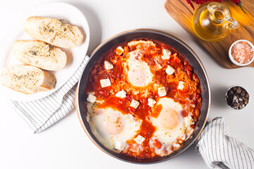 Shakshuka made of poached eggs in tomato pepper sauce