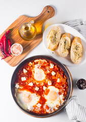 Shakshuka made of poached eggs in tomato pepper sauce