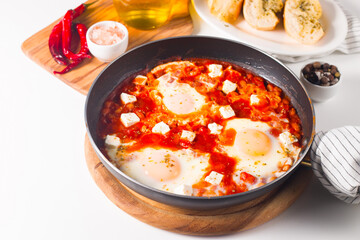 Shakshuka made of poached eggs in tomato pepper sauce