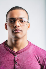 Man in maroon shirt, wearing aviators, serious