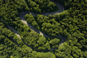 Aerial view of the road passing through the mountain and green forest. Curve asphalt road on mountain.	
