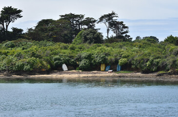 Quelques barques de couleurs, sur une plage, en Bretagne avec Mer, Golf du Morbihan, France 