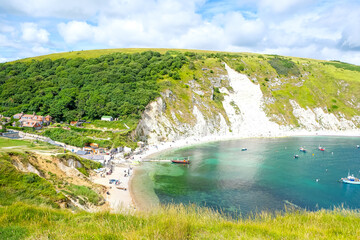 Lulworth Cove bay, beach and cliffs view . The Jurassic Coast is a World Heritage Site on the English Channel coast of southern England. Dorset, UK. crowded beach, public beach.