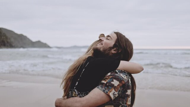 Joyful Gen Z couple enjoys fun summer evening at the beach, running, walking on sand in the ocean. Embracing love, happiness, smile, savor vacation together on the coast, creating lasting memories.