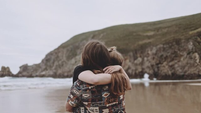 Joyful Gen Z couple enjoys fun summer evening at the beach, running, walking on sand in the ocean. Embracing love, happiness, smile, savor vacation together on the coast, creating lasting memories.