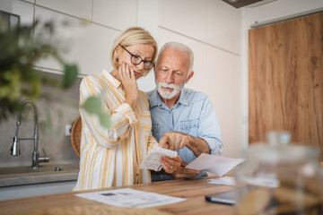 Serious angry senior couple calculate bills to pay domestic finances - Powered by Adobe