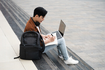 Handsome long legs of Asian men walking, listening to music and working on the street