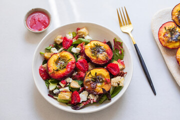 Salad with peaches baked with blue cheese and raspberry vinegrette