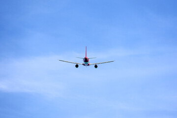 Airplane flying in blue sky, back view. Passenger plane at flight, travel concept