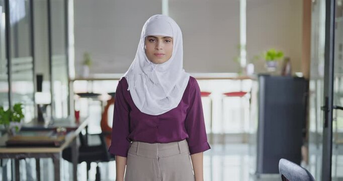 Indian smiling young adult gen z expert woman agent lady wear hijab scarf standing proud cross hands look cam indoor job office day teen boss girl staff owner fold arm pose head shot photo work place