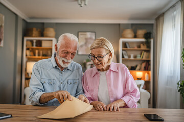 Senior couple open and read a letter document from envelope together