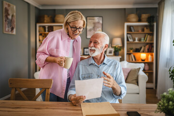Senior man read a letter document whit mature women who drink coffee