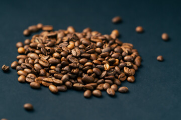 on black-blue background lie roasted coffee beans laid out preliminary check of coffee readiness...